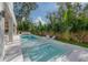 Backyard view of a long, modern pool with lounge chairs and surrounding tropical landscaping at 4110 W Swann Ave, Tampa, FL 33609