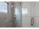 Elegant shower with gray herringbone tiles, a glass door, and bronze fixtures at 4110 W Swann Ave, Tampa, FL 33609