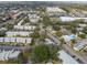 An aerial view of a condo community with pools, parking, mature trees, and nearby commercial development at 4215 E Bay Dr # 1601D, Clearwater, FL 33764