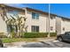 Two-story condo building exterior with manicured landscaping and visitor parking under a blue sky at 4215 E Bay Dr # 1601D, Clearwater, FL 33764