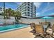 Outdoor pool area with patio seating, lounge chairs, palm trees, and a view of the building at 4400 37Th S St # 3, St Petersburg, FL 33711