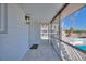 Screened porch with white walls and marble tile flooring leads to outdoor pool area at 4400 37Th S St # 3, St Petersburg, FL 33711