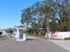Community entrance with security booth and lush landscaping, creating a secure and inviting atmosphere at 4845 Baker Ave, Zephyrhills, FL 33541
