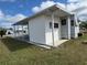 Exterior view of home with a covered patio and well-manicured lawn in a mobile home community at 4845 Baker Ave, Zephyrhills, FL 33541