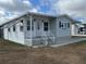 Charming mobile home with a well-maintained exterior, featuring a front porch and landscaped front yard at 4845 Baker Ave, Zephyrhills, FL 33541