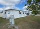 Exterior view of a white mobile home with awnings in a well-maintained community with blue skies at 4845 Baker Ave, Zephyrhills, FL 33541