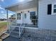 Close-up of a porch with white railings, steps, and an inviting front door at 4845 Baker Ave, Zephyrhills, FL 33541
