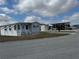 Mobile home with an inviting front porch and a convenient carport for RV parking in a friendly community at 4845 Baker Ave, Zephyrhills, FL 33541