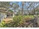 View of shady backyard with covered porch and greenery, inviting outdoor relaxation at 4928 Petunia Ct, New Port Richey, FL 34652