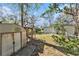 Fenced backyard with shed and mature trees, offering a private outdoor space at 4928 Petunia Ct, New Port Richey, FL 34652