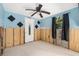 View of a bedroom with blue walls, ceiling fan, and a door, offering a comfortable living space at 4928 Petunia Ct, New Port Richey, FL 34652