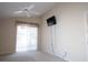 Bedroom with a ceiling fan, mounted TV and sliding glass doors at 5011 Glenburne Dr, Spring Hill, FL 34609