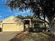 Inviting single-story home featuring a well-manicured lawn, arched entryway, and two-car garage at 5011 Glenburne Dr, Spring Hill, FL 34609