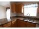 Close-up of kitchen featuring granite countertops, wood cabinets, and stainless steel sink at 5011 Glenburne Dr, Spring Hill, FL 34609