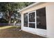 Home exterior featuring a screened lanai and a well-maintained lawn and white fence at 5011 Glenburne Dr, Spring Hill, FL 34609
