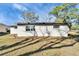 Backyard view of the home's exterior, showing roof, lawn and surrounding trees at 5602 Bay Blvd, Port Richey, FL 34668