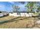 Backyard view of the home's exterior, showing roof, lawn and surrounding trees at 5602 Bay Blvd, Port Richey, FL 34668