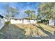 Backyard features healthy lawn and a view of the home's exterior and roof at 5602 Bay Blvd, Port Richey, FL 34668