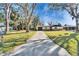 Spacious property featuring a lengthy driveway, mature trees, and a charming single-story home with stone accents at 5602 Bay Blvd, Port Richey, FL 34668