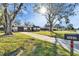 Attractive single-story home with an attached garage, mature landscaping, and a long driveway leading to the residence at 5602 Bay Blvd, Port Richey, FL 34668