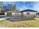 A well-maintained home features a stone facade, a well-kept lawn, and an attached garage at 5602 Bay Blvd, Port Richey, FL 34668