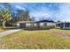 Charming one-story home features a stone facade, well-manicured lawn, and attached garage at 5602 Bay Blvd, Port Richey, FL 34668