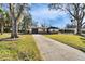 Charming single-story home boasts a well-manicured lawn, stone accents, mature trees, and attached garage at 5602 Bay Blvd, Port Richey, FL 34668