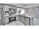 Bright, updated kitchen features stainless appliances, marble counters and backsplash, and a large island with seating at 5602 Bay Blvd, Port Richey, FL 34668