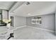 Living room area with marble floors adjacent to open concept kitchen with abundant light, all in a modern home at 5602 Bay Blvd, Port Richey, FL 34668