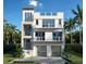 Modern three-story home featuring a minimalist design, balconies, and a two-car garage at 561 173Rd E Ave, North Redington Beach, FL 33708