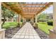 Shaded community walkway featuring a decorative arbor, landscaping, and paver blocks at 628 Arbor Lake Ln, Tampa, FL 33602