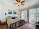 Cozy bedroom featuring a metal bed frame, ceiling fan, and a balcony with natural light at 6910 Lake Place Ct, Tampa, FL 33634