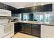 This kitchen features dark cabinetry, granite countertops, and a view into the living area at 6910 Lake Place Ct, Tampa, FL 33634