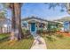 Charming home featuring a landscaped yard with a walkway leading to a light blue front door at 713 43Rd N Ave, St Petersburg, FL 33703