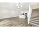 Open-concept living room with wood floors, staircase, and a modern kitchen featuring stainless steel appliances at 7529 62Nd N Way, Pinellas Park, FL 33781