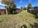 Wide view of back yard featuring shed and wood fence, with scattered foliage at 7563 Meadowlawn N Dr, St Petersburg, FL 33702