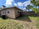 Home's exterior showing air conditioner, wood fence and green lawn at 7563 Meadowlawn N Dr, St Petersburg, FL 33702