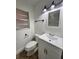 Bathroom featuring a white vanity, toilet, and modern lighting fixtures at 7563 Meadowlawn N Dr, St Petersburg, FL 33702
