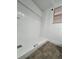 Bathroom with a white tiled shower and neutral-colored flooring at 7563 Meadowlawn N Dr, St Petersburg, FL 33702