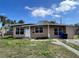 Charming single-story home with tidy landscaping and mature palm trees under a partly cloudy blue sky at 7563 Meadowlawn N Dr, St Petersburg, FL 33702