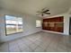 Bright living room with tile floors, fan, and custom built in shelving at 7563 Meadowlawn N Dr, St Petersburg, FL 33702