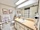 Well-lit bathroom featuring a white sink vanity, neutral paint color, and decorative artwork at 7623 Radcliffe Cir # 211A, Port Richey, FL 34668