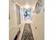 Hallway with tile floors, decorative wall art, and a long runner leading into the home at 7623 Radcliffe Cir # 211A, Port Richey, FL 34668