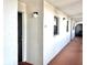 Condo hallway with the entrance door, exterior light fixture and exterior windows at 7623 Radcliffe Cir # 211A, Port Richey, FL 34668