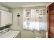 Charming laundry area with a washer, decorative curtains, and unique shelving at 7623 Radcliffe Cir # 211A, Port Richey, FL 34668