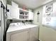 Neat laundry room with white cabinetry, washer, and dryer, featuring cute decorations at 7623 Radcliffe Cir # 211A, Port Richey, FL 34668