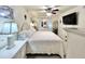 Well-lit main bedroom with a comfortable bed, elegant white furniture, and a mounted television at 7623 Radcliffe Cir # 211A, Port Richey, FL 34668