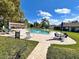 Community pool featuring comfortable lounge chairs, tables, and a clear blue swimming pool, surrounded by landscaping at 7623 Radcliffe Cir # 211A, Port Richey, FL 34668