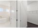Doorway view of bathroom with closet, soaking tub, and vanity at 8977 Players Dr, Brooksville, FL 34613