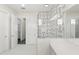 Bright bathroom featuring a shower with stylish gray and white patterned tiling and a double sink vanity at 8977 Players Dr, Brooksville, FL 34613